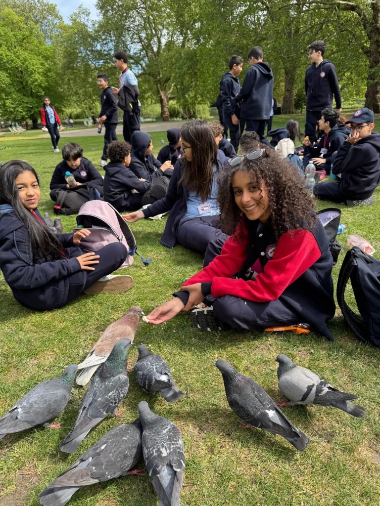 Students from Alexander Flemming take a lunch break at St James's Square Garden, feeding pigeons.