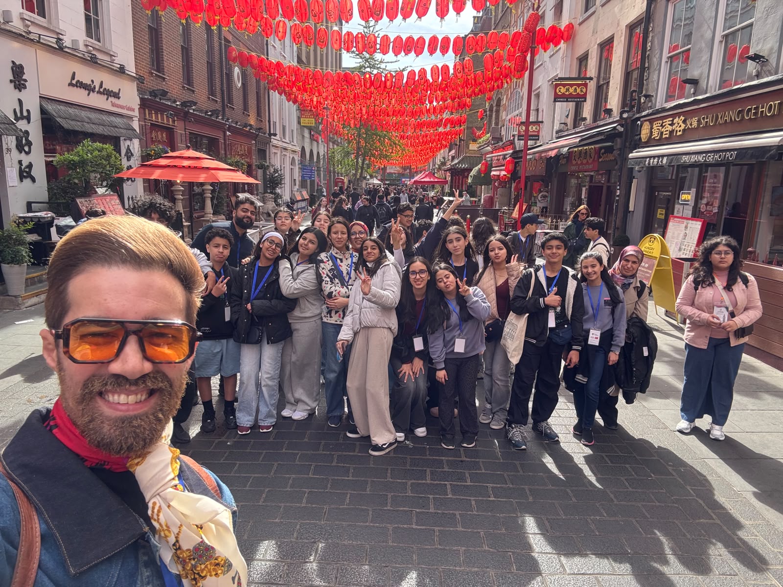 Students pose with AIS activity leader Ilyas in front of China Town in London